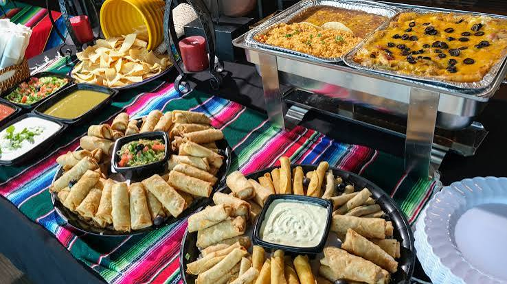Taquito platters, salsas and chafing trays at a Sol Agave catering setup
